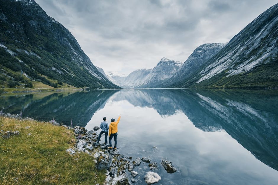 Nature image showing two people looking over a fjord