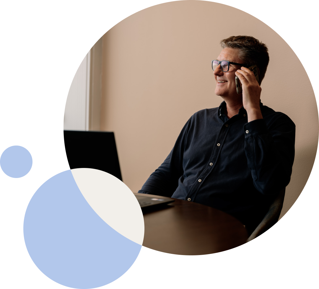 A man on a phone call at his desk