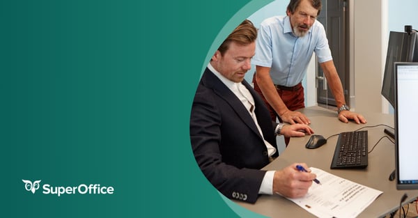 Photo of two men working in front of a computer in the office